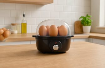 Яйцеварка с яйца върху плот в светла кухня.