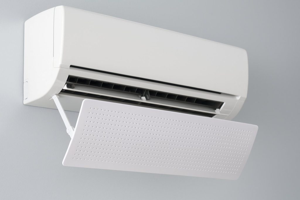 Бял стенен климатик с монтиран въздушен дефлектор на светлосин фон.
