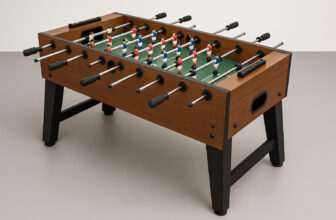 Джага маса с дървен корпус, черни крака и фигури в червено и синьо върху зелено игрално поле.