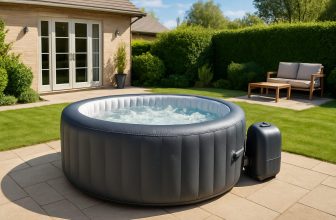 Кръгло надуваемо джакузи със съвременен дизайн, разположено на тераса в озеленен заден двор на къща в слънчев ден