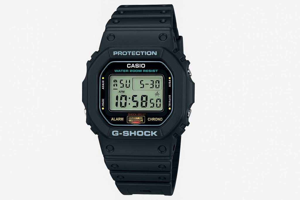 Защо G-Shock Остава Ненадминат? История и модели 6 Черен цифров часовник с правоъгълен дисплей, жълти и сини акценти и надпис „G-SHOCK“ върху бял фон