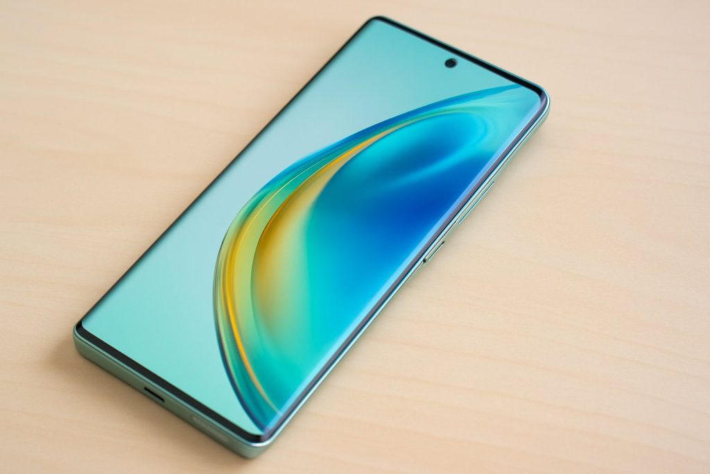 Honor Magic 5 Lite с активен дисплей, поставен върху светла дървена повърхност.