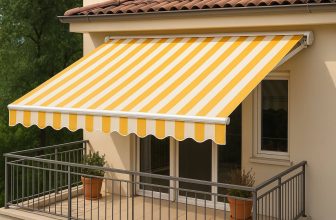 Разпъната тента с жълто-бели райета над балкон с керемиден покрив.